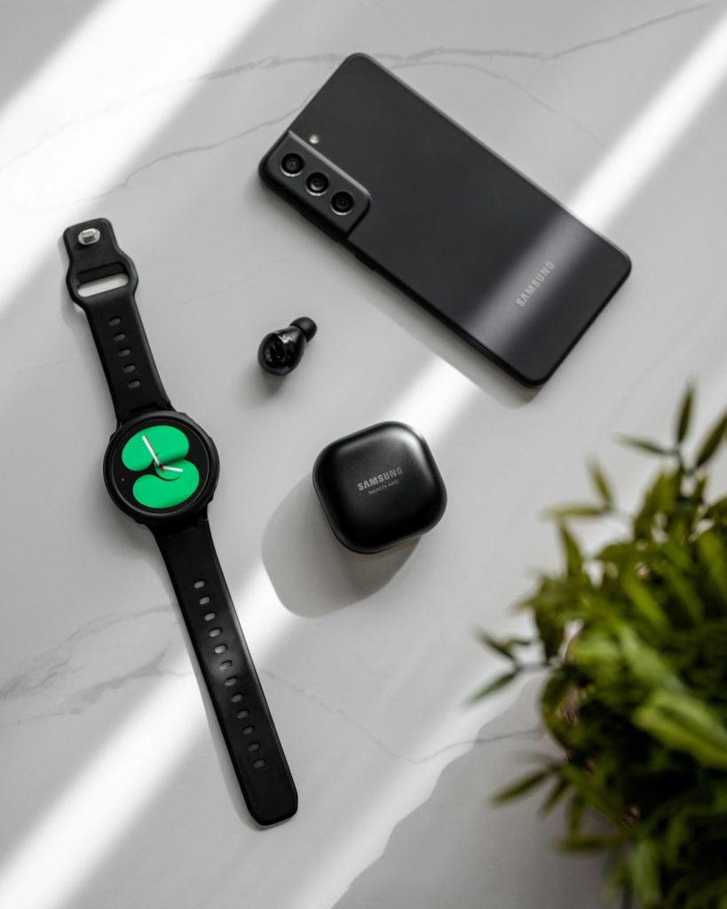 a-smart-watch-a-cell-phone-and-a-plant-on-a-table-dsjwqlonfbq